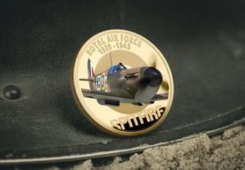 The RAF Battle of Britain Spitfire Coin on metal surface and sand on forefront