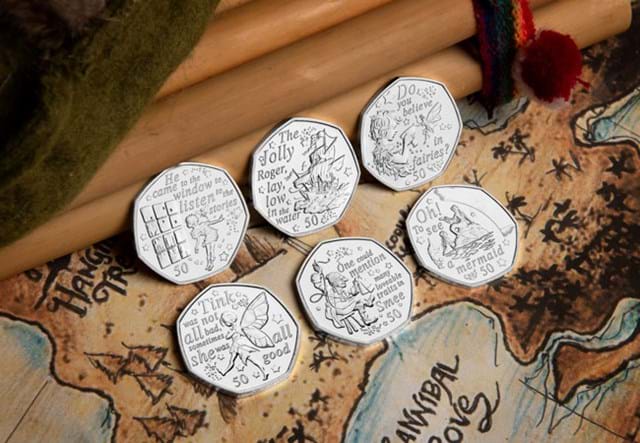 The 2020 Official Peter Pan 50p Coin Set Reverses leaning against wooden surface