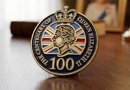 This pin badge has been issued to mark the centenary of Elizabeth II' s birth. The pin badge features a portrait of the Queen which has been coloured with enamel. 